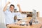 Celebrating the companys latest success. Portrait of a businessman raising his arms in victory while sitting at his desk