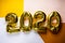 Celebrating the New Year 2020, golden foil balloons 2020 on colorful backgrounds. Foil balls