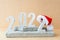Celebrating the new year 2022. Number 2022 in concrete numbers with a New Year`s hat on concrete podiums.