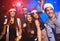 Celebrating New Year together. Group of beautiful young people in Santa hats throwing colorful confetti, looking happy