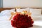 Celebrating Saint Valentine`s Day with bouquet of red roses, glass of champagne and croissants on tray on bed