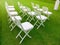 Celebration arrangment of the white wooden chairs on the grass