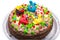 Celebration colorful cake decorated with fruit, chocolate and figures of animals for kids party