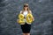 Celebration concept with golden balloons. Young woman in suit holding air balloons on grey background