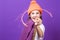 Celebration Concept. One Expressive Winsome Caucasian Girl in Coral Winter Warm Hat and Violet Knitted Scarf Having Fun With Vivid