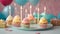Celebration Cupcakes: Colorful cupcakes with lit candles displayed against a backdrop of wrapped gifts. Captured indoors