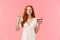 Celebration, happiness concept. Attractive dreamy redhead girl in lovely white dress, holding b-day cake, cross finger