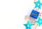 Celebration white background with wrapped classic blue giftbox with gold ribbon, bright party streamers and shiny blue stars.