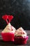 Celebratory cupcake for Valentines day and happy birthday on wooden black background with hearts. Give love on a holiday
