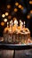 Celebratory scene birthday cake with candles on wooden table, lights