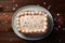 Celebratory top view birthday cake with confetti on wooden background