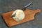 Celeriac with a knife on a cutting board on a gray background