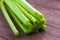 Celery closeup on wooden background. Stems of fresh organic green celery closeup. Healthy eating, diet concept