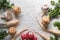 Celery roots, parsley, radishes with leaves and garlic on a white table free space