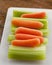 Celery Stalks and Carrots on White Plastic Cutting Boardl