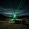 Celestial Symphony: Enchanting Green Laser Pierces Desert Night\\\'s Silence