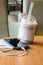 Cell phone charging in the cafe with a plastic cup of iced chocolate frappe