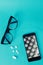 Cell phone flat lay with glasses and medication