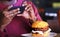 Cell phone photographing a burger. Hamburger on cafe table