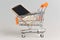 Cell phone in supermarket pushcart on gray background