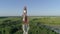 Cell phone telecommunication tower, drone view of worker servicing antenna