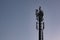 Cell phone tower / communications antenna or mast in silhouette at dusk against dark blue sky.