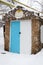 Cellar with closed blue and white metal doors, winter in snowy weather