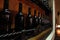 Cellar shelves with dark corked wine bottles against light brown wooden wall.