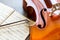 Cello and its bow with a music sheets on wooden background with copy space . Rehearsal before the concert. Musical tuition concept