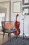 Cello or violoncello musical instrument with wooden chair and pillow