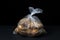 Cellophane bag with potatoes on a black background
