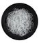 Cellophane or glass noodles in black matte plate isolated on a white background, top view