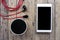 Cellphone and bluetooth speaker and earphone on wooden background