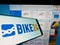 Cellphone with logo of German bicycle e-commerce company Bike24 GmbH on screen in front of business web page.