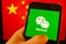 Cellphone with WeChat logo in front of the flag of China.