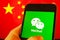 Cellphone with WeChat logo in front of the flag of China.