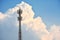 Cellular transmission tower with white clouds and blue sky background.