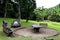 Cement benches and table for picnic in the middle of the garden. Deep forest in the background. Sao Paulo Botanical Garden