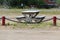 A cement picnic table behind a chain link fence