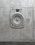 Cement sculpture in the shape of a sound speaker on a concrete facade wall. 3D wall panel of audio system. Creative conceptual