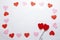 Cenital plane. White background with red and pink hearts with two heart-shaped lollipops.