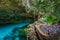 Cenote Dos Ojos in Quintana Roo, Mexico. People swimming and snorkeling in clear blue water. This cenote is located close to