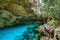 Cenote Dos Ojos in Quintana Roo, Mexico. People swimming and snorkeling in clear blue water. This cenote is located close to