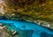 Cenote Dos Ojos in Quintana Roo, Mexico. People swimming and snorkeling in clear blue water. This cenote is located close to