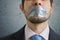 Censorship concept. Man is silenced with adhesive tape on his mouth