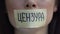 Censorship word in Russian on tape, woman removing mouth sticker, restriction