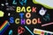 In the center of the black background, the inscription is BACK TO SCHOOL, made in colored letters. Bright colored school