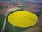 Center pivot irrigation system on a yellow rapeseed field aerial view