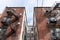 Centered view of a light well between apartment building wings, metal fire escapes, urban housing composition