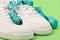 Centimeter in cyan blue color curled on white trainers